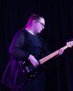Mulligrub performing on stage with a guitar.