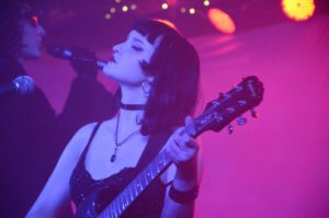 Winterruption performer on stage with a guitar in hand.
