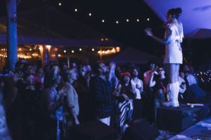 Artist performing on stage in front of an audience at night.