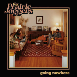 Two people playing guitar in a living room. Image is neutral tones with a thin beige frame and a thick black border. Top left text reads "the Prairie Joggers" and the bottom right reads "going nowhere."